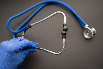 Stethoscope on black background, top view. Medical instrument