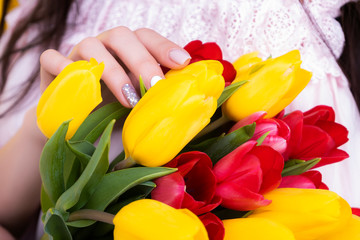 Obraz premium Mothers Day. A large bouquet of tulips close-up in female hands.