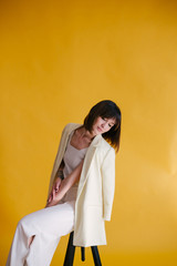 Woman in trendy clothes on yellow background.