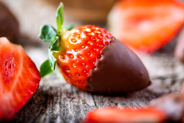 fresa con chocolate en un fondo rústico