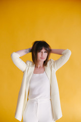 Fototapeta premium Woman in trendy clothes on yellow background.
