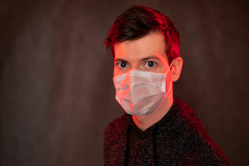 Guy in medical mask. A simple man in a medical protective mask protecting against viruses. Red...
