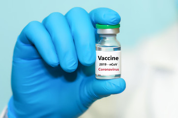 A doctor is holding a coronavirus vaccine. The concept of vaccination, medicine, healthcare.