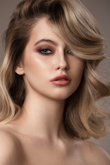 Portrait of young blonde woman. Long beautiful wavy hair.