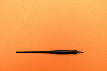 Calligraphy pen on blank orange textured paper