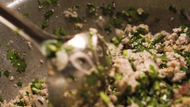 Someone strirring up a minced pork in a pot. Making of Larb. Spicy pork Thai salad. Isaan menu. Slow motion