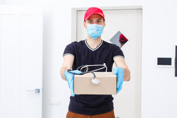Obraz na płótnie Canvas Delivery man holding cardboard boxes in rubber gloves and medical mask. copy space. Fast and free Delivery transport . Online shopping and Express delivery