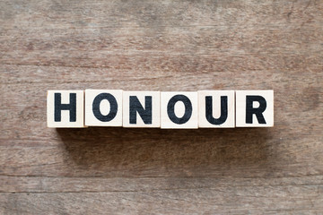 Fototapeta na wymiar Letter block in word honour on wood background