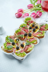 Catering - canape with fresh tuna and arugula in a ceramic plate. Restaurant serving. Close up, Selective focus, vertical. Slices Of Baguette With Fresh Tuna