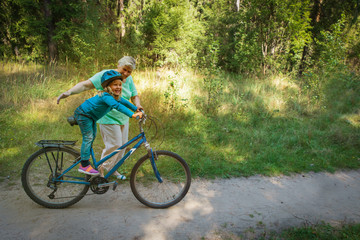 grandmother teaching little granddaughter to ride bike
