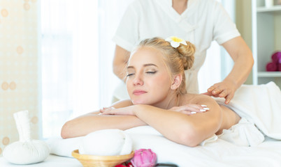 Obraz na płótnie Canvas Concept of traditional thai massage relax and body health care .Beautiful caucasian woman getting back and shoulder massage in spa salon.blonde beautiful girl enjoying a massage at the health spa.