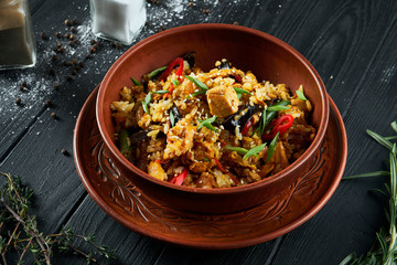 Light, diet pilaf with beef and carrots on a white plate on a wooden background. Top view with copy space for text. Traditional oriental cuisine