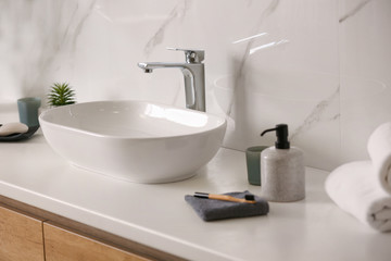 Fototapeta na wymiar Stylish vessel sink on light countertop in modern bathroom