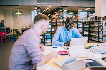 Obraz premium Male students studying together in library