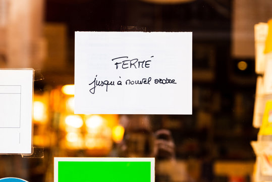 Handwritten french sign on a bookstore window reads closed until further notice, in Bayonne, France