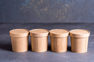 Paper coffee cups on blue concrete background.