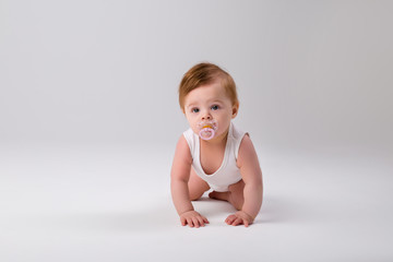 baby with a pacifier in his mouth on a white background, space for text