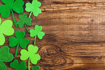 Flat lay composition with clover leaves on wooden table, space for text. St. Patrick's Day celebration