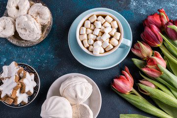 Beautiful spring tulip flowers , a cup of coffee and cakes on rustic wooden background. Flat lay.