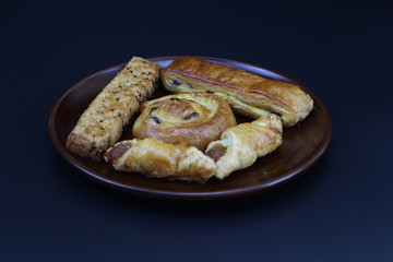 Bread in a brown plate and a black background