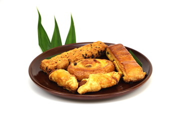 Bread in brown plate and pandan leaves and white background