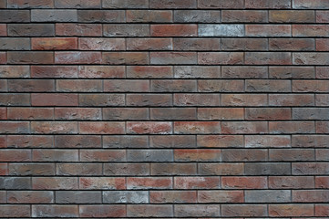 A brown brick wall with a decorated rough surface. Background