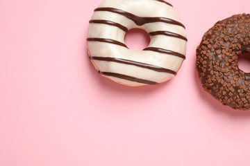 Delicious glazed donuts on pink background, flat lay. Space for text