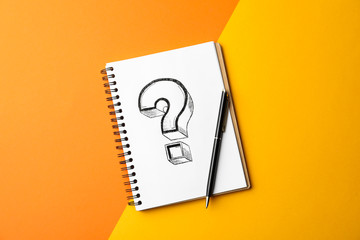 Notebook with question mark and pen on color background, top view