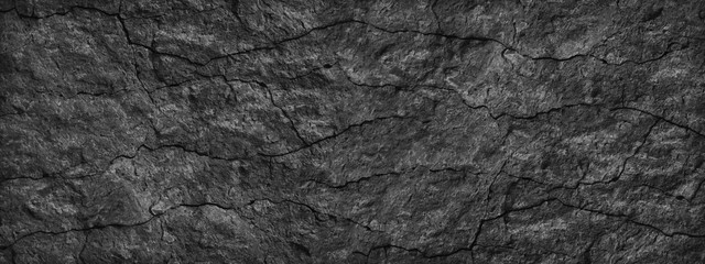 Cracked stone surface. Close-up. Black abstract grunge background. Banner with black rock texture....