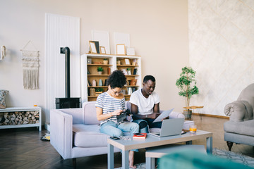 Woman putting credit card to bag while black man reading document