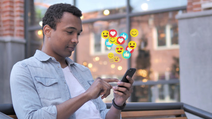 African Man Using Smartphone, Emoji, Comments and Likes