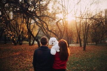 owner and white poodle dog outdoors in autumn