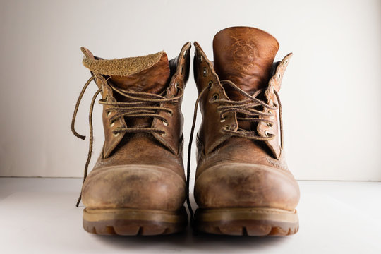 Old leather brown boots isolated in a white background.