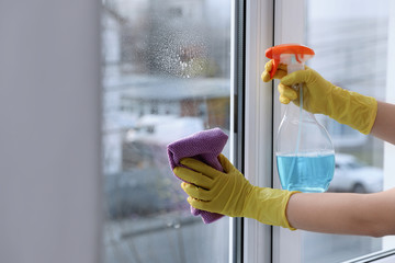 Woman cleaning window at home, closeup. Household chores