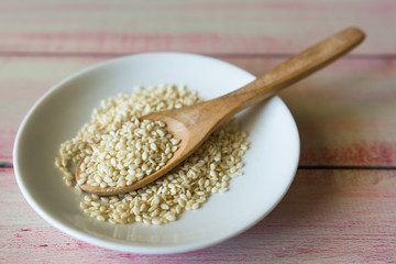Closeup of sesame seeds in a wooden spoon.