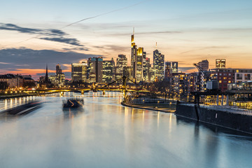 Fototapeta premium Sonnenuntergang über Frankfurt Skyline, Schiffe im Main