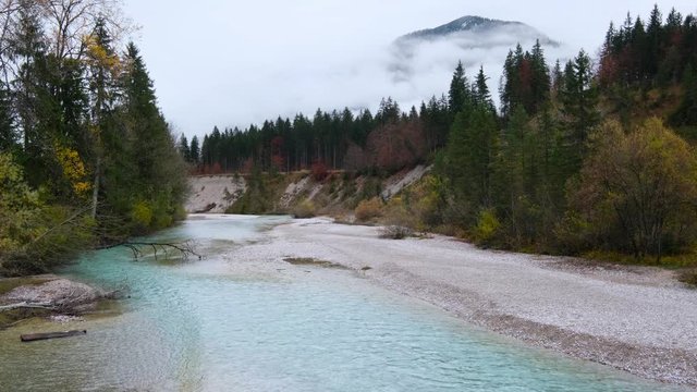 Autumn overcast day on Karwendel Bavarian Prealps and Isar river flow, Germany. Picturesque traveling, seasonal and nature beauty concept scene.