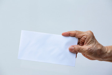Senior woman's right hand holding white envelope or bride isolated on white background, Close up and macro shot, Business concept