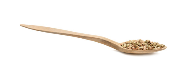 Green buckwheat on a wood spoon seen from the side and isolated on white background