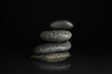 Fototapeta na wymiar Stones in water on black background. Zen lifestyle