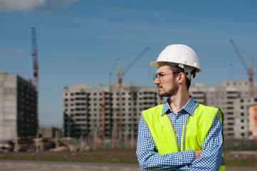 Portrait of Young Man Engineer In Green Vest With Plan