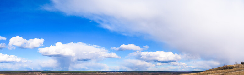 panorama of blue sky with white clouds on a clear Sunny day. photo for the banner. space for text