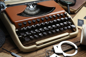 Fototapeta na wymiar Typewriter on wooden table, closeup. Detective's workplace