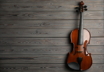 Fototapeta na wymiar Classic violin on wooden background, top view. Space for text