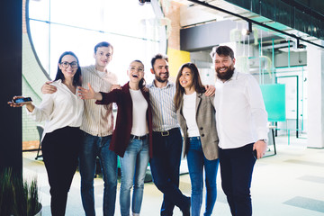 Successful coworkers hugging in workplace