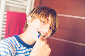 Young boy brushing his teeth on waking up in the bathroom New day of ordinary life