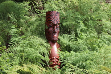 Sculpture Totem Maorie dans les fougères - obrazy, fototapety, plakaty