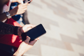 Anonymous man using empty screen smartphone at city street