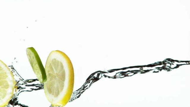 Super slow motion of lime and lemon slices with water splash on white background. Filmed on high speed cinema camera, 1000 fps.
