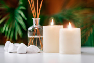 Aromatherapy Concept. Aromatic White Candles and Essential Oil Reed Diffusers